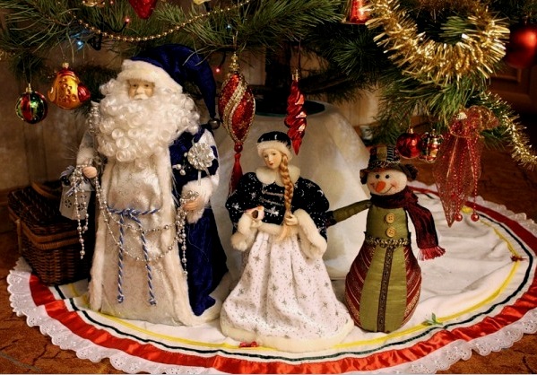 Figuras de Papá Noel y la Doncella de Nieve bajo el árbol