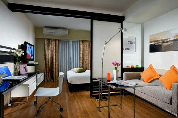 Dormitorio y sala de estar en una habitación de un apartamento pequeño.
