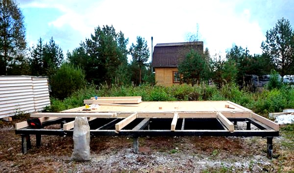 Construcción independiente de una casa de marco sobre una base de pilotes