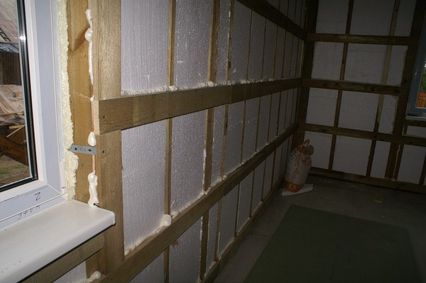 El procedimiento para aislar las paredes de una casa de marco con lana mineral y otros materiales.